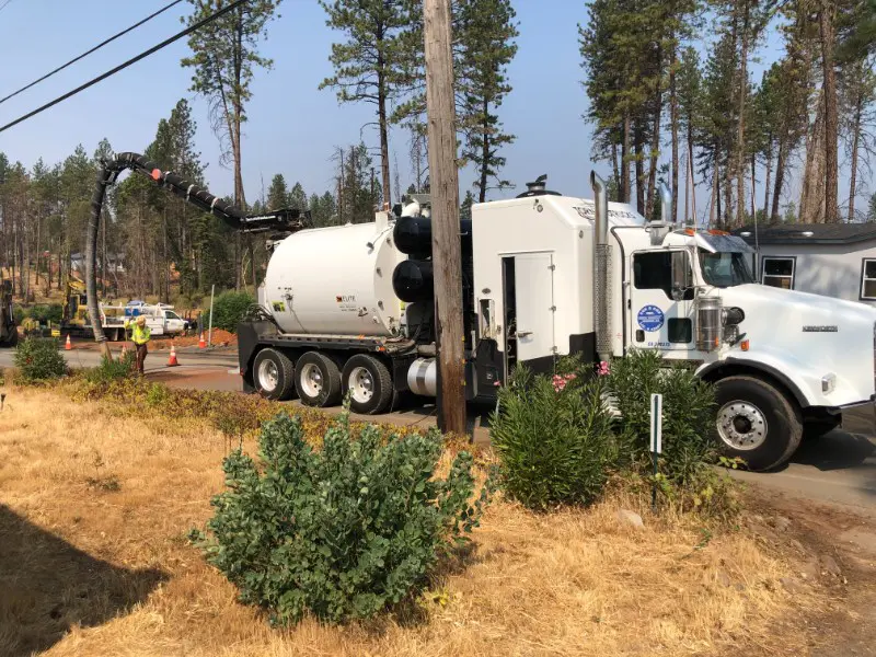 Rear quarter view of a cement truck delivering a load of concrete to a construction site.